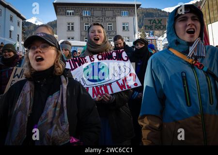 Davos, Suisse. 14 janvier 2024. Davos, CH 14 janvier 2024. Les manifestants portant des pancartes marchent jusqu'à Davos pour protester contre le 54e Forum économique mondial. Des centaines de manifestants se sont rassemblés pour exprimer leurs préoccupations au sujet de l'ordre du jour du FEM de cette année. Le Forum engage les dirigeants politiques, commerciaux et culturels de la société à façonner les agendas mondiaux, régionaux et industriels, qui peuvent avoir un impact sur tout le monde dans le monde. Crédit : Andy Barton/Alamy Live News Banque D'Images