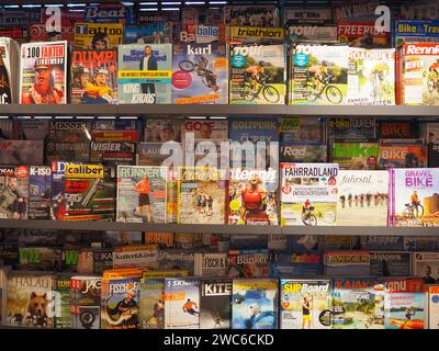 Vue frontale de l'étagère à magazines dans la librairie de la gare, divertissement, section sports, allemand, pages de couverture, gens, vélo, coureur, magazines de voyage Banque D'Images