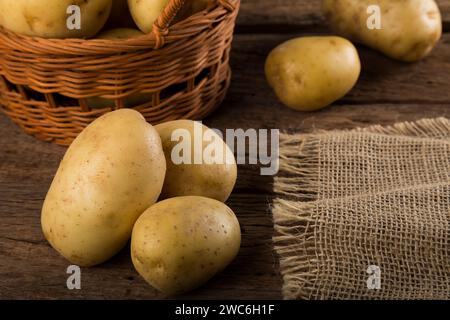 Pommes de terre fraîches sur la table en bois. Pommes de terre crues. Banque D'Images
