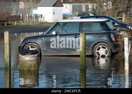 Wallingford, Oxfordshire, Royaume-Uni. 14 janvier 2024. La Tamise à Wallingford, Oxfordshire, a éclaté cette semaine et inondé le parking Riverside. Certaines voitures ont été totalement submergées dans les eaux de crue. Un polo mini et VW attendent la récupération. Crédit : Maureen McLean/Alamy Live News Banque D'Images