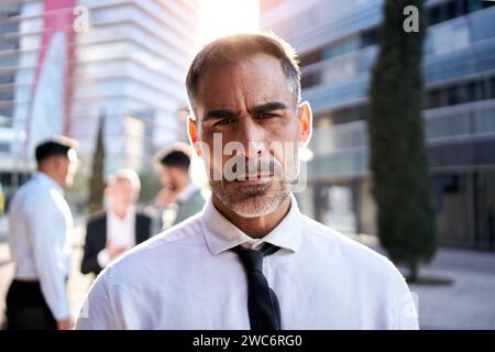 Portrait d'un homme d'affaires séduisant d'âge moyen regarde l'appareil photo expression sérieuse debout à l'extérieur. Banque D'Images