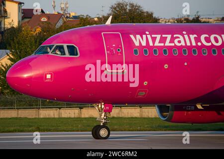 L'Airbus A320 de la compagnie aérienne hongroise low cost Wizzair se rapproche lors d'un roulage au sol après avoir atterri à Lviv pendant l'heure d'or Banque D'Images