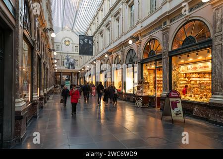 Les gens font du shopping aux Galeries Royale Saint-Hubertus, une galerie marchande en verre à Bruxelles. Banque D'Images