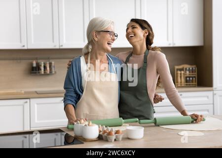 Heureuse maman mûre excitée et fille adulte portant des tabliers Banque D'Images