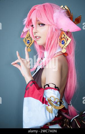 Une cosplayer féminine dans un costume d'anime rose portant des cheveux roses Banque D'Images