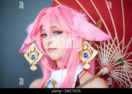 Une cosplayer féminine dans un costume d'anime rose portant des cheveux roses Banque D'Images