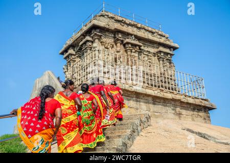 Groupe de pèlerines vêtues de sarees rouges et jaunes colorés sur le chemin du temple Olakkannesvara, Mahabalipuram, région de Tondaimandalam, Tamil Nadu Banque D'Images