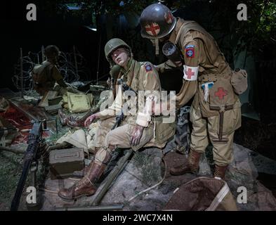 Reconstitution d'une scène de la Seconde Guerre mondiale d'un médecin soignant un soldat américain blessé sur le champ de bataille Banque D'Images