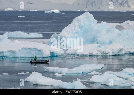 Zodiac naviguant à travers les eaux glacées de Neko, port, Antarctique, vue rapprochée des icebergs au sol se reflétant sur les eaux environnantes Banque D'Images