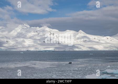 Zodiac naviguant à travers les eaux glacées de Neko, port, Antarctique, vue rapprochée des icebergs au sol se reflétant sur les eaux environnantes Banque D'Images