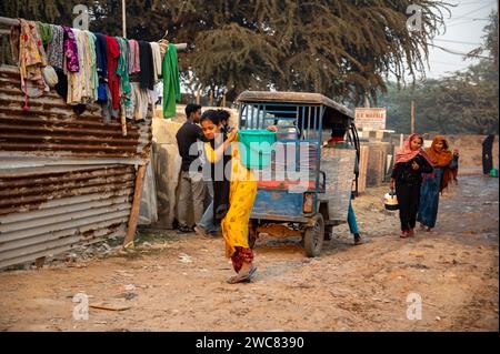 New Delhi, Inde. 14 janvier 2024. Une réfugiée rohingya rentre chez elle en transportant de l’eau potable dans un récipient en plastique récupéré à un point de distribution dans le camp de réfugiés Rohingya de Madanpur Khadar. 1 100 Rohingyas vivant dans les camps de Madanpur Khadar dépendent de l’approvisionnement en eau municipal. (Image de crédit : © Pradeep Gaur/SOPA Images via ZUMA Press Wire) USAGE ÉDITORIAL SEULEMENT! Non destiné à UN USAGE commercial ! Banque D'Images