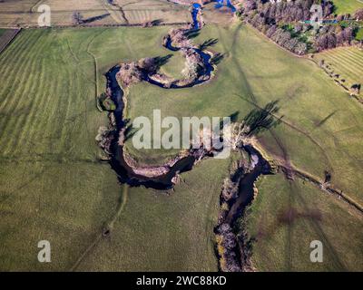 Une vue aérienne de la petite rivière torsadée Arrow qui traverse la campagne du Warwickshire par une journée d'hiver ensoleillée. Banque D'Images