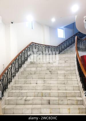 L'arrière-plan de l'image présente une cage d'escalier vide et élégante, soulignant le design minimaliste. Banque D'Images