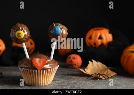 Délicieux desserts décorés comme des monstres sur une table grise. Halloween Banque D'Images