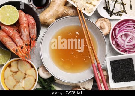 Cuisiner une délicieuse soupe ramen. Différents ingrédients frais dans des bols et des baguettes sur la table, à plat Banque D'Images