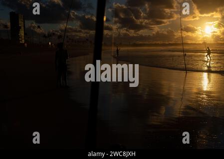 Salvador, Bahia, Brésil - 27 avril 2019 : des pêcheurs pêchent à l'aube sur la plage de Jaguaribe dans la ville de Salvador, Bahia. Banque D'Images