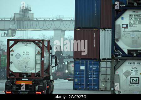 Duisburg, Allemagne. 12 janvier 2024. Les conteneurs sont chargés au port. L'Office fédéral de la statistique annonce le produit intérieur brut pour 2023. Le produit intérieur brut est une mesure de la performance économique d'une économie. Crédit : Federico Gambarini/dpa/Alamy Live News Banque D'Images