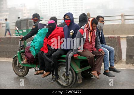 Dhaka, Bangladesh. 14 décembre 2012. Les gens se rendent à leur lieu de travail en pleine journée d'hiver à Dhaka, au Bangladesh, le 13 janvier 2023. Le Bangladesh a enregistré sa température la plus basse à 8,8 degrés à Dinajpur. Le froid arrivé tard cette saison s’est enfin installé fermement. La lumière du soleil est rare en raison du brouillard dans diverses parties du pays, et les gens souffrent en raison du froid intense. Photo de Habibur Rahman/ABACAPRESS.COM crédit : Abaca Press/Alamy Live News Banque D'Images