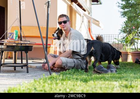 Griller avec de la viande crue dessus. Il y a des cevapcici, patty Burger pour griller. C'était l'été et l'heure du pique-nique bbq. La nourriture est cuite dans le jardin. Banque D'Images