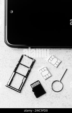 Smartphone et emplacements ouverts pour cartes nano SIM, deux cartes nano SIM, lecteur micro SD et clé métallique, photo noir et blanc Banque D'Images