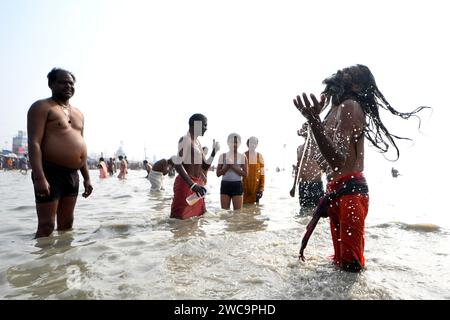 Île de Sagar, Inde. 14 janvier 2024. Un Sadhu indien prend un bain sacré pendant le festival de Gangasagar. Gangasagar est l'un des endroits religieux pour les pèlerins hindous situé dans la baie du Bengale où chaque année des millions de dévots viennent prendre un bain Saint pendant Makar Sankranti (transition du soleil) selon le calendrier hindou et offrir des prières au temple Kapil muni. La date de ce Festival tombe généralement entre le 13 et le 15 janvier de chaque année. Crédit : SOPA Images Limited/Alamy Live News Banque D'Images