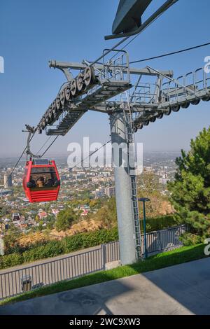Un téléphérique rouge, gondole arrive à la station supérieure. Au sommet de la montagne zone de parc d'attractions touristique de Kok Tobe à Almaty, Kazakhstan. Banque D'Images