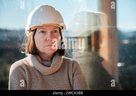 Architecte femme portant un casque blanc posant sur le chantier de construction, focalisation sélective Banque D'Images