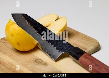une pomme coupée en deux par un couteau sur un hachoir Banque D'Images