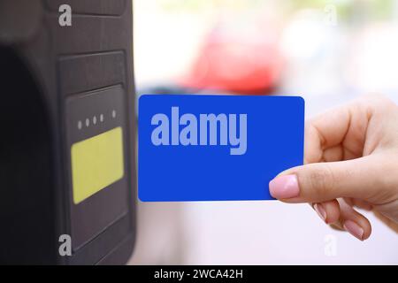 Gros plan portrait d'une femme main payant parking avec carte de crédit vierge dans la rue Banque D'Images