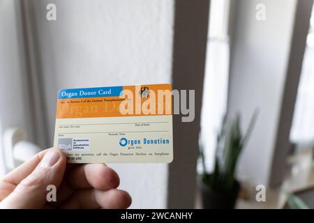 Augsbourg, Bavière, Allemagne - 14 janvier 2024 : homme titulaire d'une carte de donneur d'organe *** Mann hält einen Organspendeausweis dans der Hand Banque D'Images