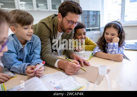 Élèves faisant des sciences avec professeur en classe. Banque D'Images