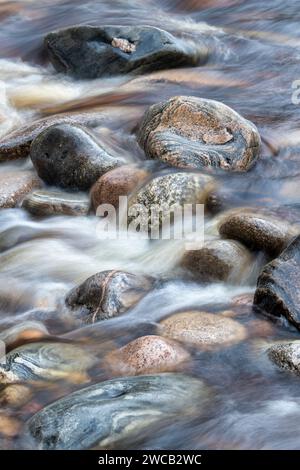 Eau qui coule rapidement sur les rochers. River Findhorn, Morayshire, Écosse. Résumé de longue exposition Banque D'Images