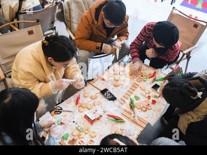 (240115) -- WUHAN, 15 janv. 2024 (Xinhua) -- des élèves apprennent à faire des biscuits lors d'un cours du soir dans la zone de développement high-tech du lac est de Wuhan, dans la province du Hubei en Chine centrale, le 24 décembre 2023. Les cours du soir étaient très populaires en Chine dans les années 1980, lorsque de nombreux jeunes cherchaient à acquérir de nouvelles compétences pour gagner leur vie. Aujourd'hui, ces classes gagnent à nouveau en popularité parmi les jeunes générations chinoises, répondant à leurs besoins pour un style de vie enrichi. Fin novembre, une école du soir pour les jeunes a été lancée par le comité municipal de Wuhan de la Ligue de la jeunesse communiste de Chine Banque D'Images