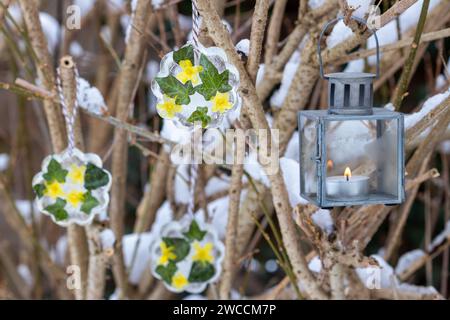 arrangement d'hiver avec des figures de glace avec des fleurs de jasmin d'hiver et des feuilles de lierre et lanterne Banque D'Images