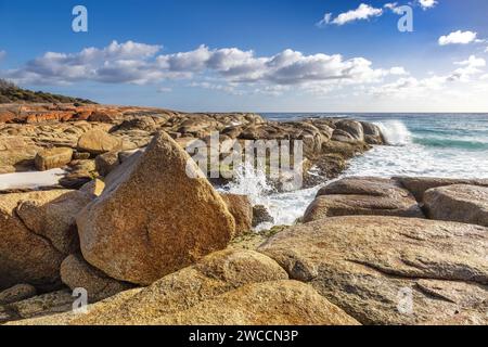 Lichen couvert de rochers à Bay of Fires, dans l'est de la Tasmanie. Ciel d'été avec rupture sur les rochers de granit. Banque D'Images