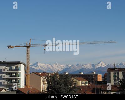 Grue à tour dans Un chantier de construction en face de la Skyline urbaine avec des montagnes en arrière-plan Banque D'Images