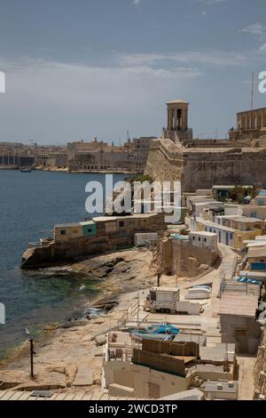 Une scène pittoresque de front de mer avec un plan d'eau calme reflétant les bâtiments environnants et les bateaux à Valette, Malte Banque D'Images