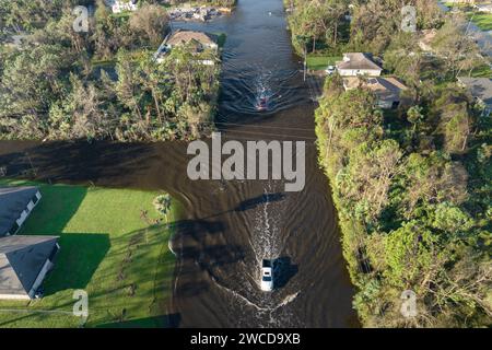 Vue aérienne de la rue inondée après la pluie d'ouragan avec des voitures de conduite dans la zone résidentielle de Floride. Conséquences des catastrophes naturelles Banque D'Images