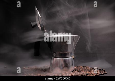 Cafetière italienne et grains de café sur fond noir Banque D'Images