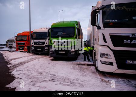 Medyka, Pologne, 15 janvier 2024. Un chauffeur de camion vérifie son camion alors qu'il attend sur un parking sur l'autoroute A4 pour traverser la frontière polono-ukrainienne alors que la grève du syndicat polonais des transports se poursuit. L'Union exige la renégociation des accords de transport entre l'Ukraine et l'Union européenne. Les manifestants ont bloqué 3 points de passage pour le transport par camion, autorisant seulement 4 camions par heure, à l'exclusion de l'aide humanitaire et militaire et des produits chimiques et alimentaires sensibles. La grève a commencé le 6 novembre. Les conducteurs ukrainiens disent attendre plus de 10 jours, les responsables polonais disent que la file d'attente est de 115 heures. Crédit : Dominika Zarzycka/ Alam Banque D'Images