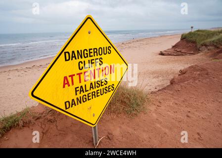 Panneau jaune bilingue avertissant les gens de falaises dangereuses érodées à Darnley, Île-du-Prince-Édouard, Canada Banque D'Images