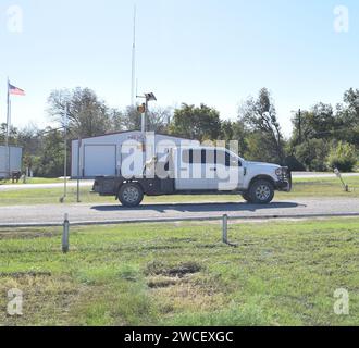 Chien debout sur un camion de travail blanc par une journée ensoleillée claire à Cranfills Gap Texas - novembre 2023 Banque D'Images