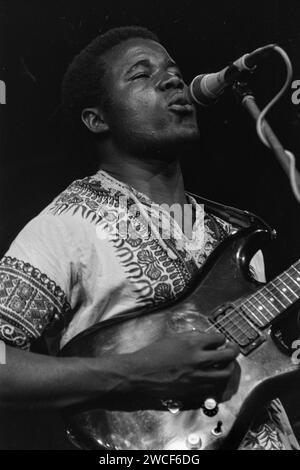 Les Bhundu Boys se produisent au premier week-end WOMAD à Carlyon Bay à Cornwall, en Angleterre, en 1987. Le groupe zimbabwéen, qui jouait un type de musique connu sous le nom de jit, est devenu très rapidement populaire au Royaume-Uni et en Europe et a joué au stade de Wembley en 1987 avec Madonna. Sur la photo : Biggie Tembo, guitare et voix. Banque D'Images