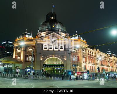 Vue colorée de la gare de Flinders Street située au coin animé de Flinders Street et Swanston Streets illuminée la nuit à Melbourne en Australie. Banque D'Images