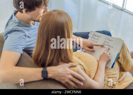 Un couple expectant choisit joyeusement un nom pour son fils à naître, savourant le moment spécial de choisir une identité significative pour sa famille grandissante Banque D'Images