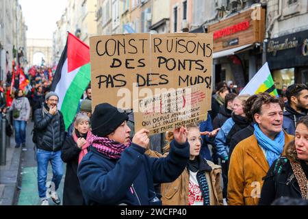 Marseille, France. 14 janvier 2024. Les manifestants brandissent des pancartes et des drapeaux palestiniens pendant la marche de solidarité avec Gaza. 2 500 manifestants selon la police ont manifesté dans les rues de Marseille, de la place d'Aix à la Préfecture de police, en soutien au peuple palestinien. Crédit : SOPA Images Limited/Alamy Live News Banque D'Images