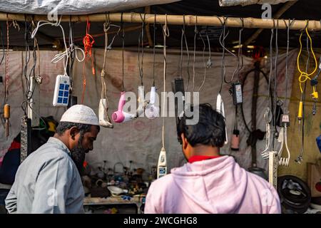 Jaynagar, Inde. 15 janvier 2024. Les clients recherchent des produits électroniques usagés à l'intérieur d'une foire à la ferraille au Bengale occidental. Les habitants de Mathurapur Bengale occidental, en Inde, ont observé une bonne pratique de gestion des déchets en organisant une sorte de foire, la «Bhanga Mela» (Une foire des articles de rebut), où ils exposent des objets ménagers usagés et abandonnés à la vente. Des milliers de personnes viennent ici pour acheter ces produits de rebut ou des biens d'occasion pour les utiliser dans leurs maisons. Crédit : SOPA Images Limited/Alamy Live News Banque D'Images