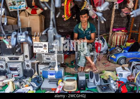 Jaynagar, Inde. 14 janvier 2024. Un vendeur de ferraille électronique est assis avec ses stocks de haut-parleurs usagés dans une foire de ferraille au Bengale occidental. Les habitants de Mathurapur Bengale occidental, en Inde, ont observé une bonne pratique de gestion des déchets en organisant une sorte de foire, la «Bhanga Mela» (Une foire des articles de rebut), où ils exposent des objets ménagers usagés et abandonnés à la vente. Des milliers de personnes viennent ici pour acheter ces produits de rebut ou des biens d'occasion pour les utiliser dans leurs maisons. Crédit : SOPA Images Limited/Alamy Live News Banque D'Images