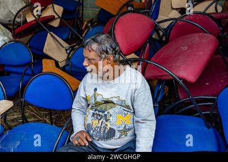 Jaynagar, Inde. 15 janvier 2024. Un homme, qui vend des chaises d'occasion, est assis avec sa collection dans une foire de la ferraille au Bengale occidental. Les habitants de Mathurapur Bengale occidental, en Inde, ont observé une bonne pratique de gestion des déchets en organisant une sorte de foire, la «Bhanga Mela» (Une foire des articles de rebut), où ils exposent des objets ménagers usagés et abandonnés à la vente. Des milliers de personnes viennent ici pour acheter ces produits de rebut ou des biens d'occasion pour les utiliser dans leurs maisons. Crédit : SOPA Images Limited/Alamy Live News Banque D'Images