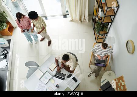 Gestionnaires, développeurs et concepteurs travaillant sur l'application mobile dans le bureau, vue de dessus Banque D'Images